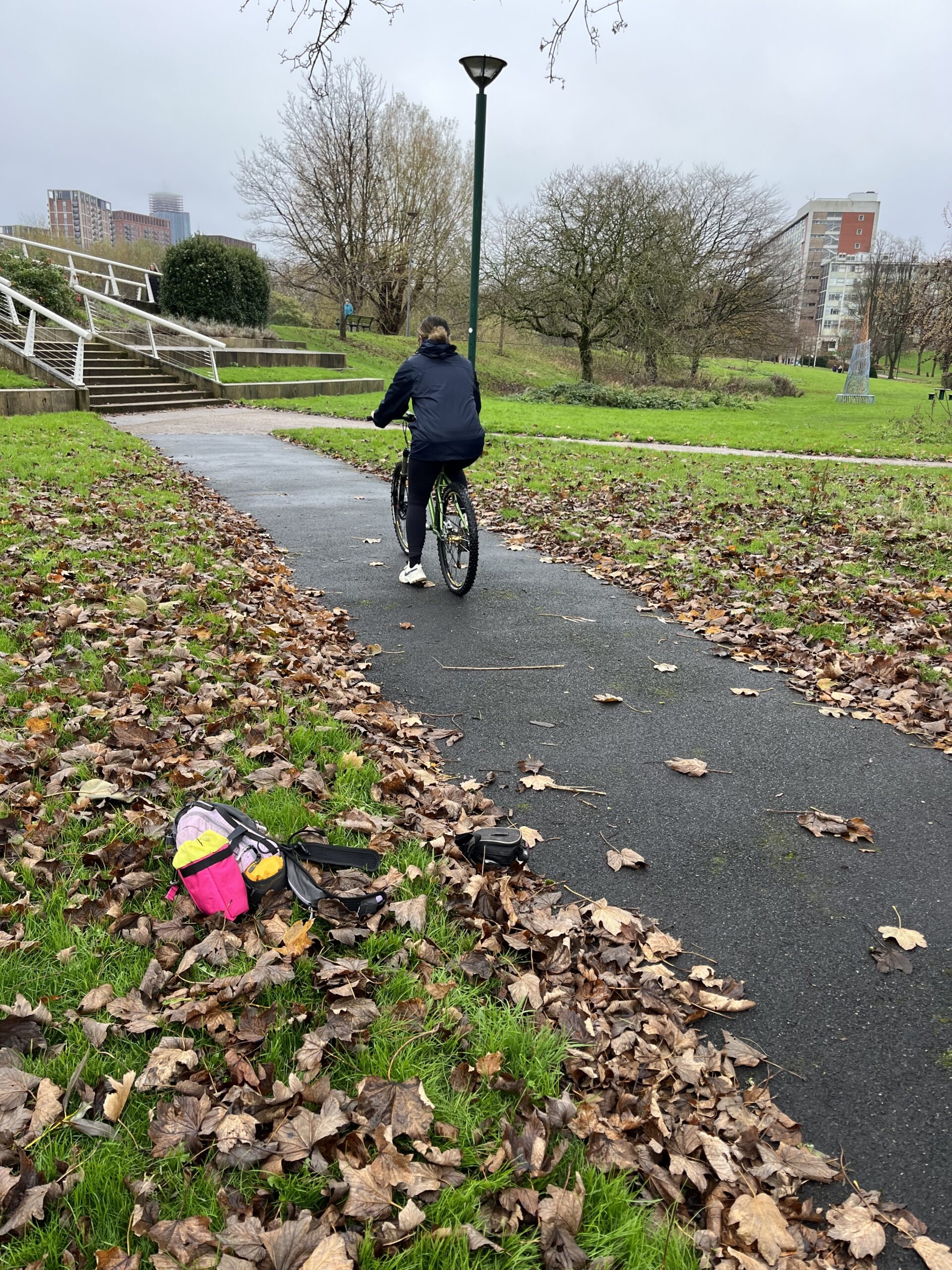 An Adult cycling a bike in a park