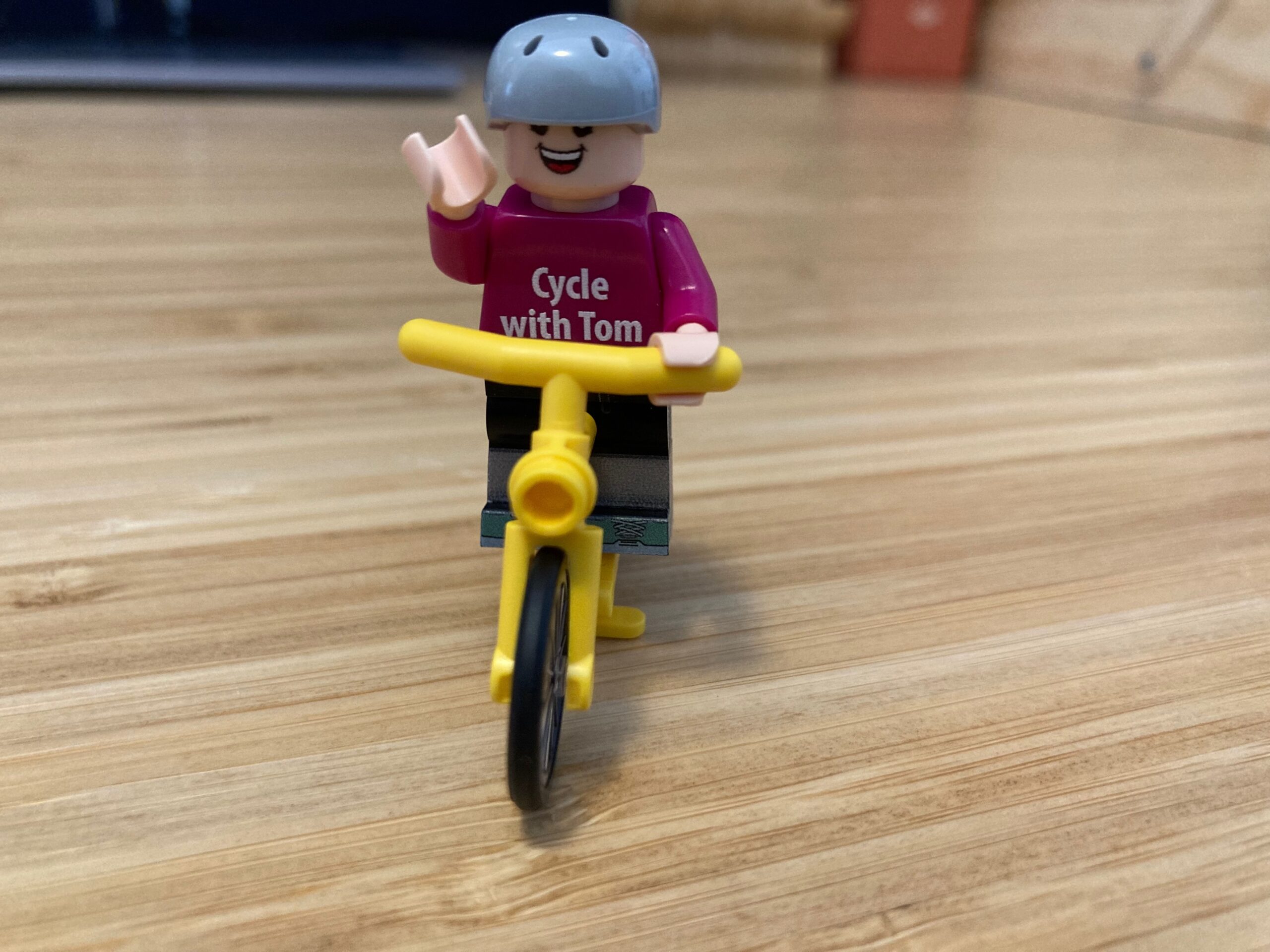A lego person on a yellow bicycle